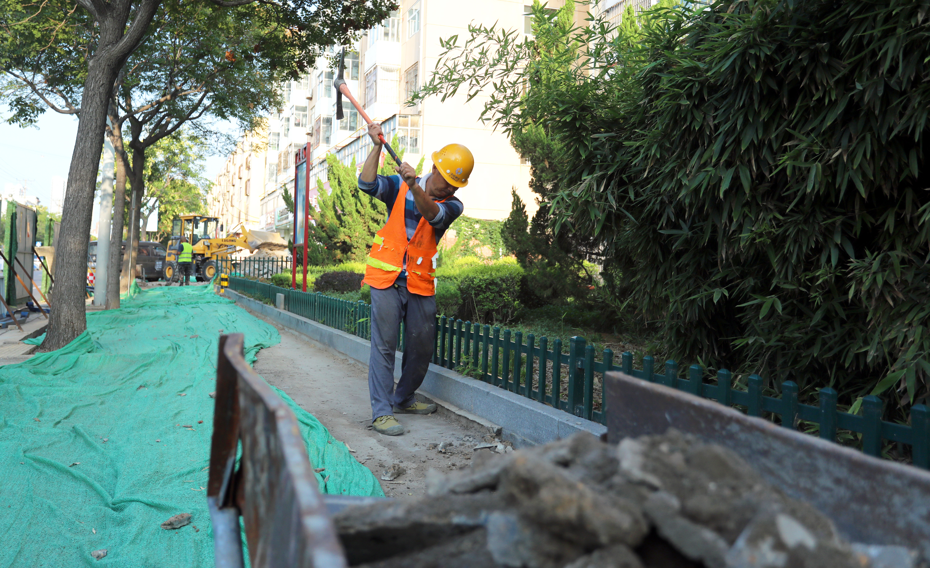 施工现场,有的搬砖,有的铺砖分工明确,呈现出一幅热火朝天的劳动场景